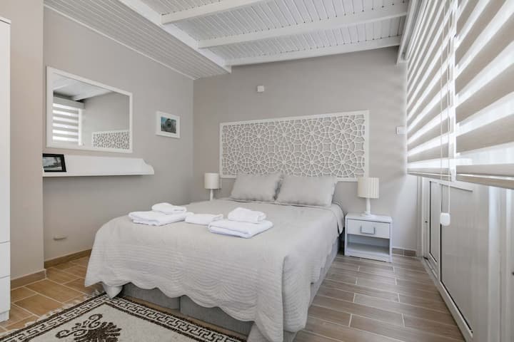 Chambre spacieuse avec lit Queen, canapé confortable et balcon privé. Détendez-vous avec style et profitez d'un mélange parfait de confort et de charme. Votre retraite tranquille vous attend.