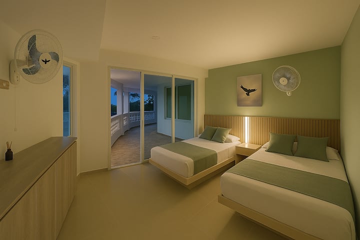 Chumba cha 6 kwenye ghorofa ya chini karibu na bustani (kiwango sawa na bwawa), chenye vitanda viwili. Mlango wa kioo unaoteleza na dirisha wima linaloangalia miti. Samani za nguo, feni 2 za ukuta na mapazia kwa ajili ya faragha.