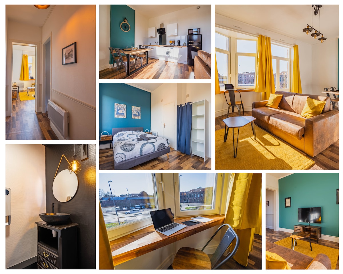 A welcoming living space features a comfortable brown sofa and a small coffee table. Large windows allow natural light to fill the room, highlighting the warm golden hues of the decor and the wooden flooring.