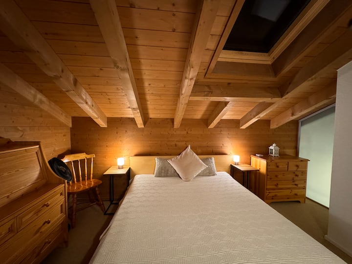 Schlafzimmer 2 im Dachgeschoss mit traumhafter Aussicht auf See und Berge, Bett 160 x 200 cm, Dachfenster mit elektrischer Verdunkelung (Aussenrolladen)