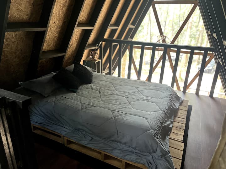 Bračni krevet s prekrasnim pogledom, zavjese od stropa do poda koje razdvajaju drugu prostoriju.