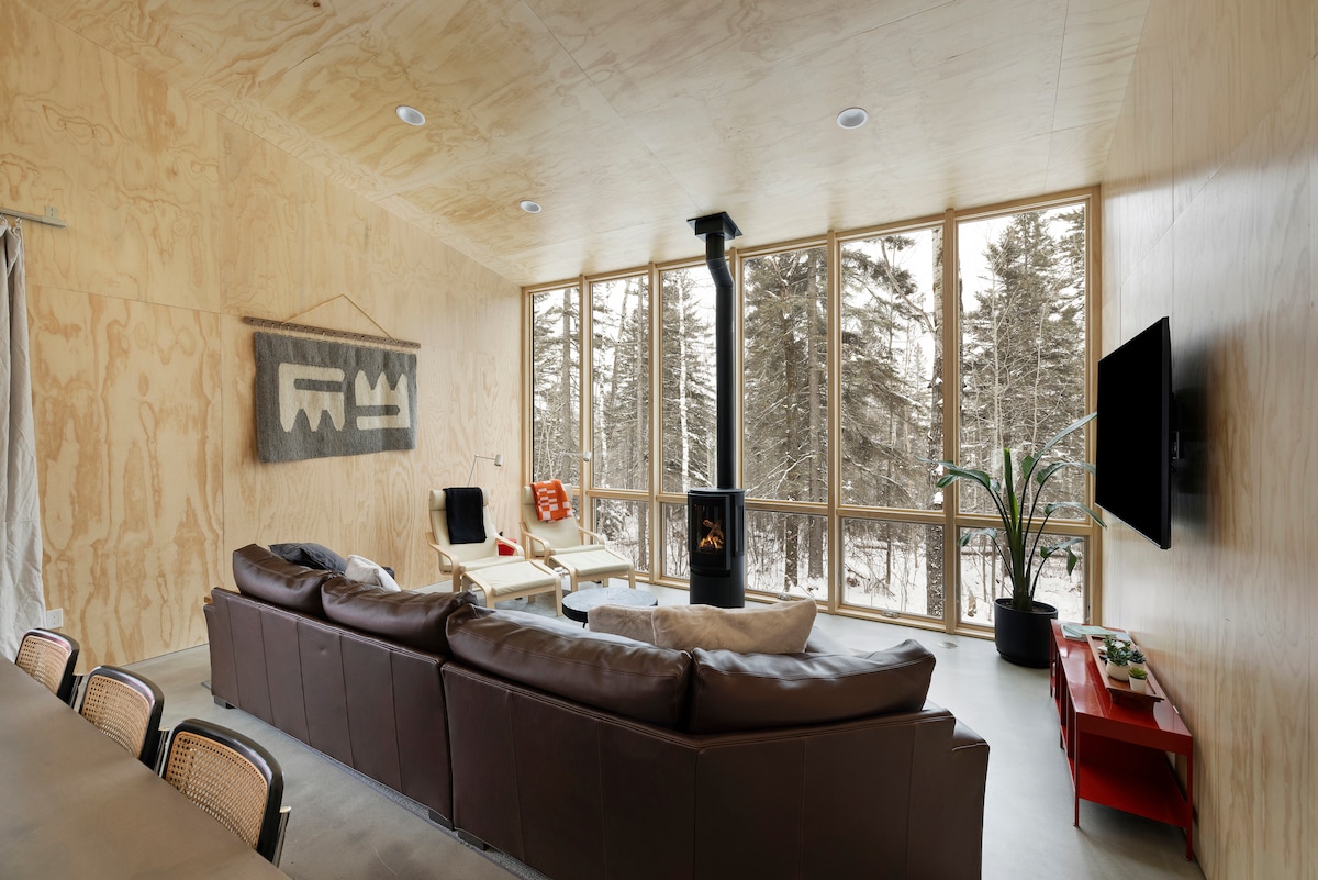 พื้นที่นั่งเล่นหลักพร้อมเตาผิงแก๊สและวิวป่าที่สวยงาม