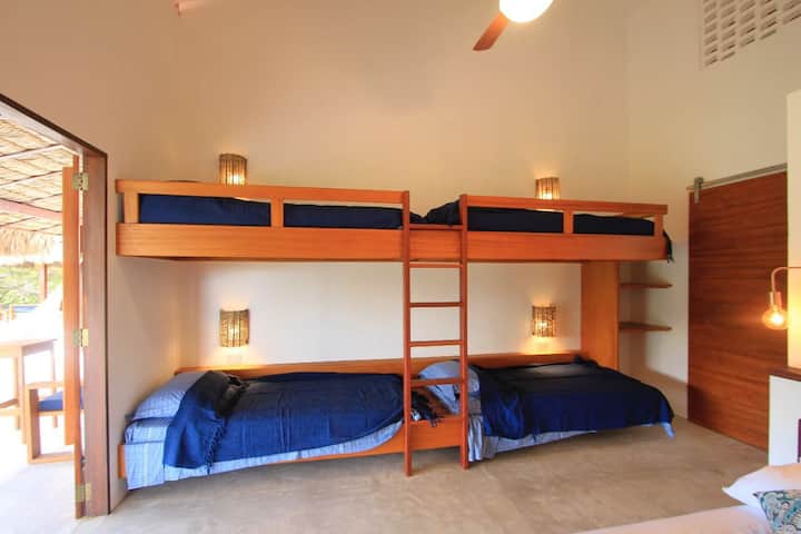 Chumba cha Familia kilicho na vitanda viwili na vitanda 2 vya ghorofa (pax 6)
Kiyoyozi, Bomba la mvua moto, usafishaji wa kila siku
Acceso kwenye roshani yenye kitanda cha bembea na mwonekano wa ua wa nyuma.
Persianas Mexicanas kwa ajili ya uingizaji hewa wa asili.
Meza ya kufanyia kazi, Wi-Fi, jeneza