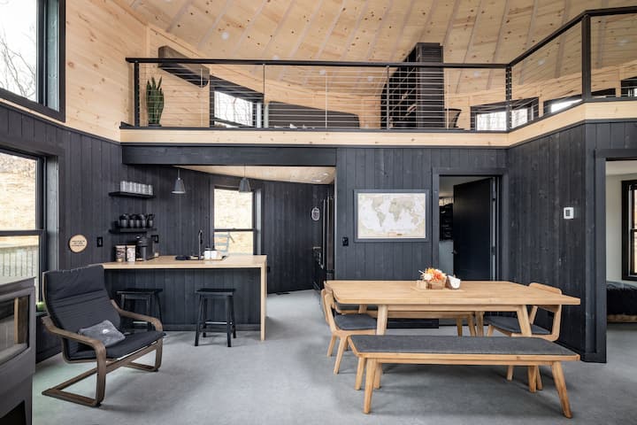 Wood Stove, Full Kitchen, Lounge Chairs, Dining Table for 8, Nespresso Machine with Supplied Pods, Modern Black-Yellow Interior, Panoramic Windows, Loft, Board Games, Pin Map - Skyline Yurt
