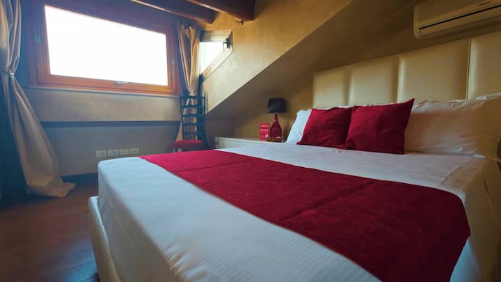 חדר מרובע הכולל חדר רחצה פרטי, מיטה צרפתית, מיטת יחיד ומיטה נפתחת אחת המשקיפה על ויה קאפלו עם נוף לבית של יוליה