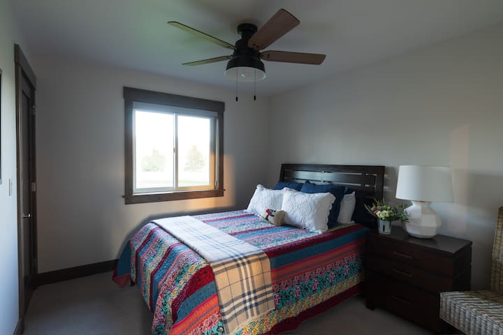 Chambre à coucher avec lit queen size au rez-de-chaussée, salle de bain attenante.