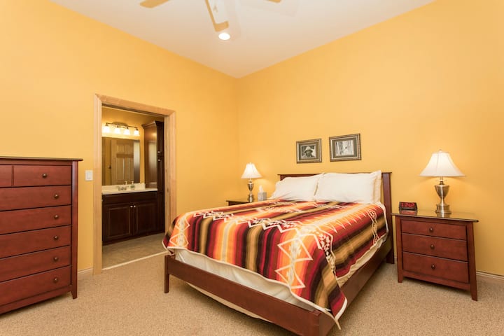 ห้องนอนควีนไซส์ชั้นแรกพร้อมทางเข้าประตูแบบพกพาไปยังห้องน้ำ 3/4 ห้อง