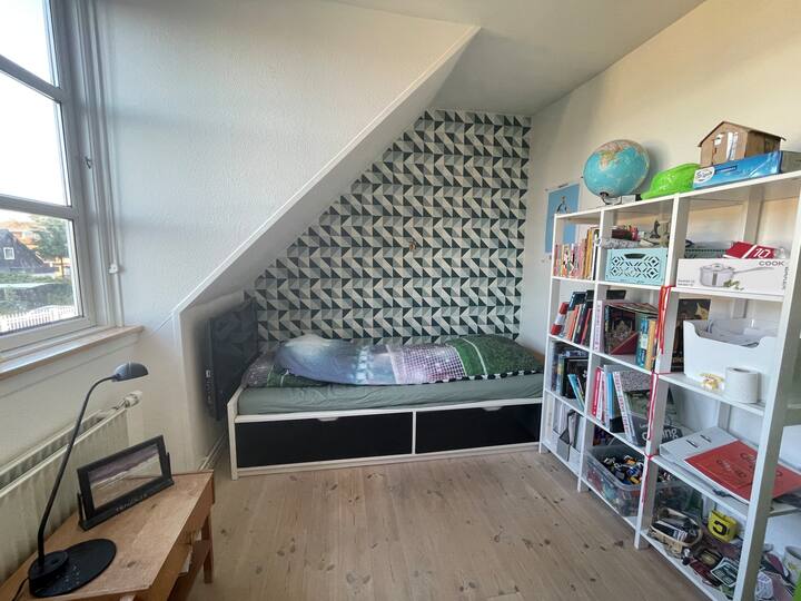Børneværelse på 1. sal med seng i voksenstørrelse. 
Der er legetøj, som man er velkommen til at bruge. 
(Vores 12-årige søn bor her.) 