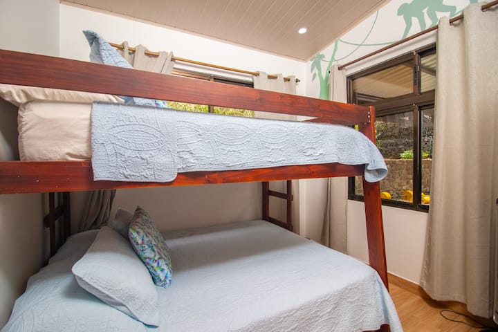 Chumba cha kufurahisha kilichohamasishwa na msitu, chenye kitanda aina ya queen/kitanda cha ghorofa chenye vitanda viwili, mchoro wa ukutani ulioundwa mahususi na kabati la nguo, kinafaa kwa wasafiri wanaotafuta likizo ya kufurahisha. 