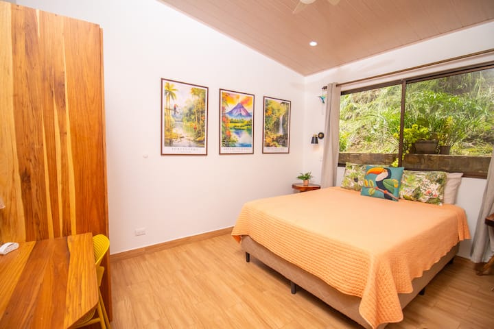 Chumba cha Kifahari cha Malkia cha Kitropiki: Kitanda aina ya queen, kabati la nguo mahususi na dawati maridadi, yakiwa yamepambwa kwa sanaa mahiri iliyohamasishwa na Costa Rica ili kutoa mandhari ya kupendeza na ya kuvutia.