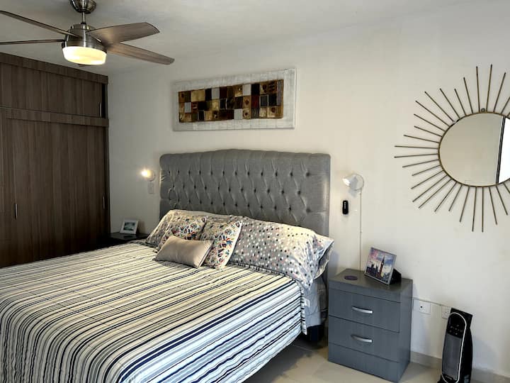 Დიდი ზომის საწოლი საძინებელი, რომელსაც თან ახლავს საკითხავი ლამპები, ჭერის ვენტილატორი, მობილური კოშკის გათბობა. 