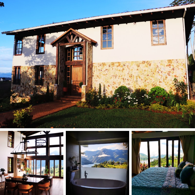 The rustic house features a charming exterior with a mix of wood and stone. Large windows frame scenic views, while vibrant gardens add color. Inside, an inviting space showcases a dining area with high ceilings, a luxurious bathtub with lake views, and a cozy sleeping space filled with natural light.