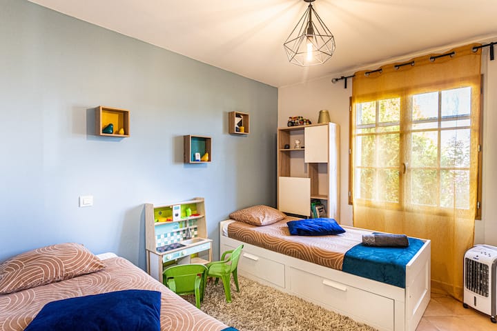 Chambre cosy avec 2 lits simples et placard de rangement.
