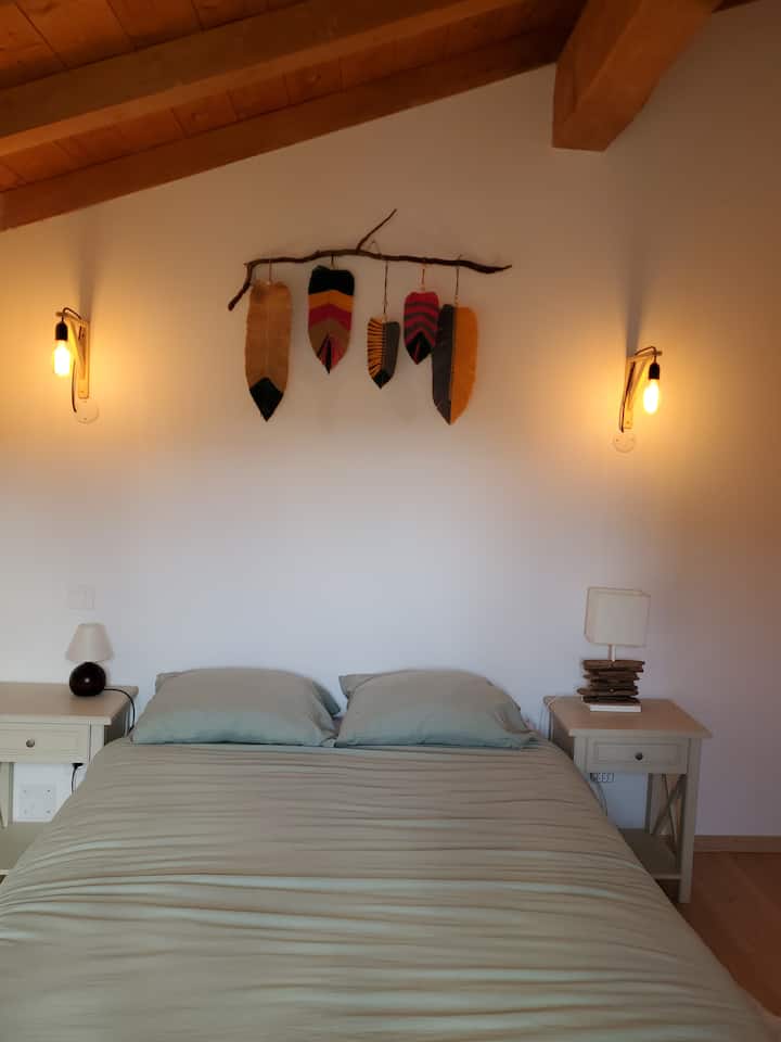 chumba cha kulala kilicho na kitanda mara mbili 140 X190 kilicho na mlango wa roshani unaoangalia milima ya kitanda. 