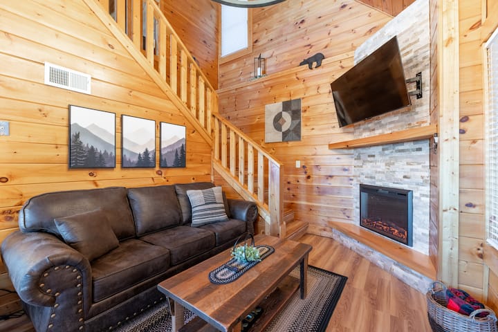 ¡Sala de estar principal que consta de un sofá cama tamaño queen, sillón de amor, mesas de café/end, chimenea de gas natural y un televisor inteligente de 55 pulgadas!
