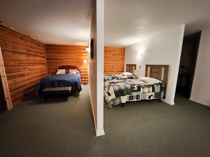 Camas de tamaño completo y dos camas individuales en un dormitorio grande en el piso principal.