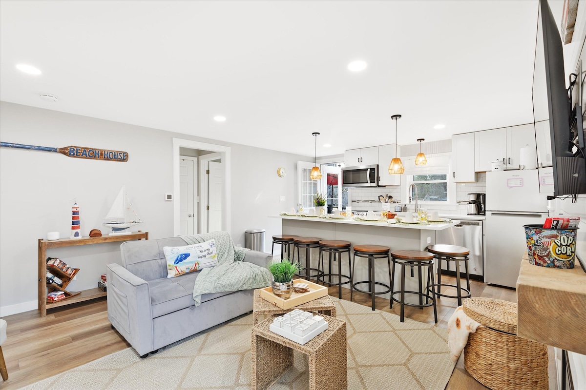 Acogedora sala de estar y cocina de concepto abierto con decoración playera.