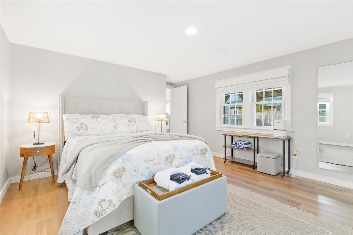 Dormitorio luminoso y espacioso con toques costeros y comodidad acogedora.