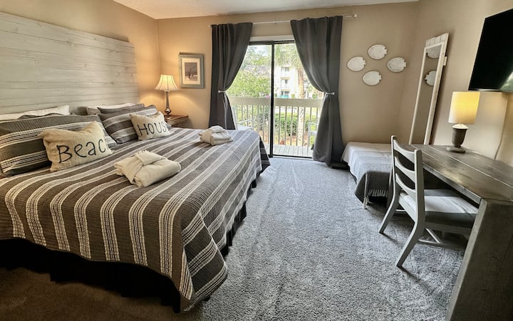 Spavaća soba na drugom katu s bračnim krevetom, TV-om i balkonom – otoman pored radnog stola otvara se u dvosjed na razvlačenje. (Plahte za dodatni dvosjed nisu osigurane.)