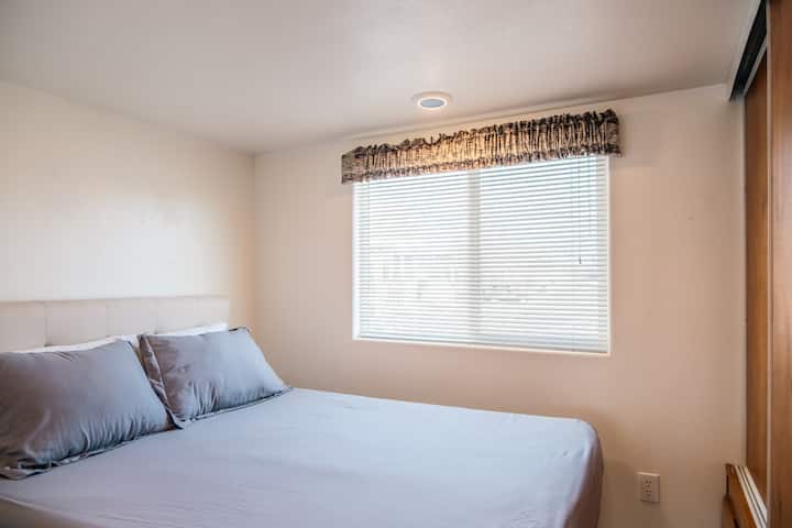La chambre principale dispose d'un lit double avec des draps confortables, de beaucoup d'espace de rangement et d'une lumière naturelle douce pour une atmosphère apaisante.