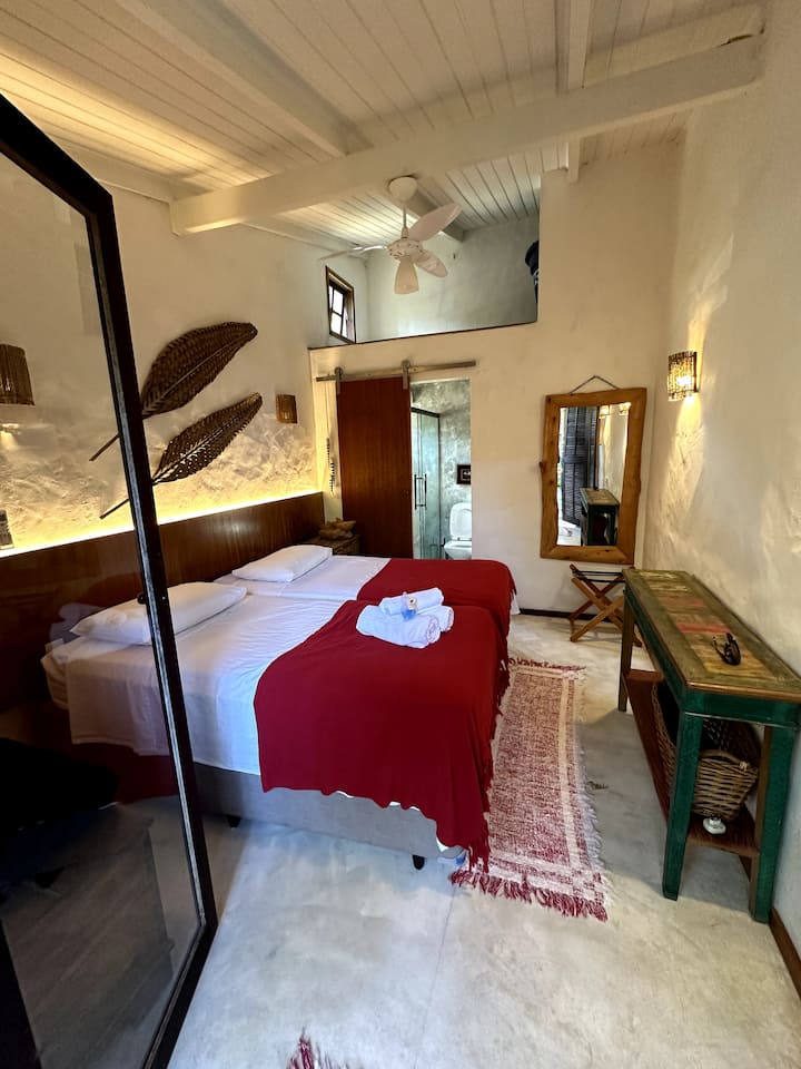 Апартман 1 - Надворешен пристап до дневната соба на куќата. Чисто, со декор на плажа, клима уред и тавански вентилатор. Топли светла за поголема удобност.
Бања со поглед кон Атлантската шума!
Нудиме крпи и постелнина.