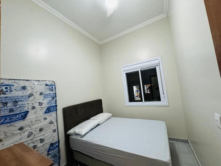Habitación con un colchón individual adicional y una cama doble con ventilador de techo.