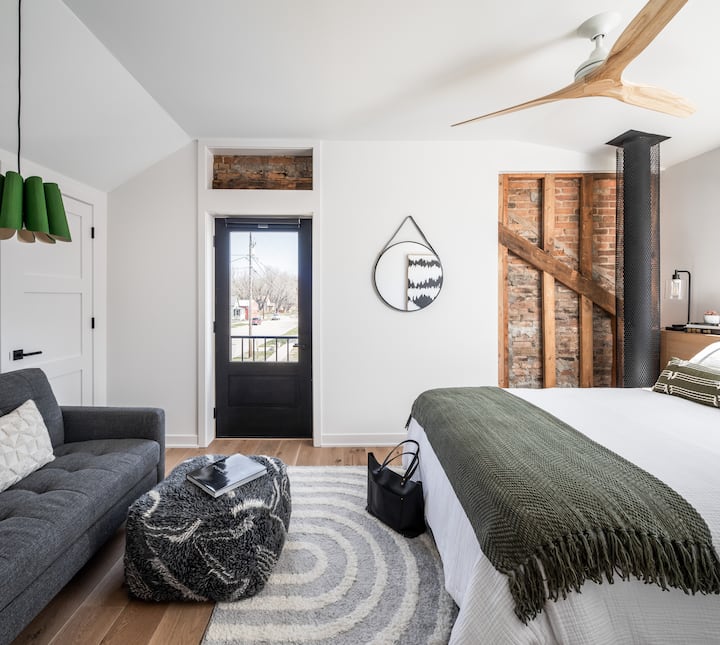 Primary bedroom has historical features like exposed original roofline, brick and beams