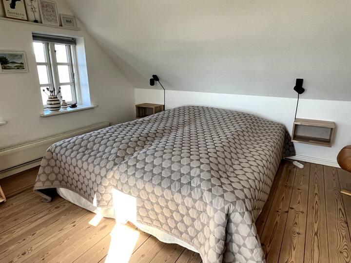 Welcome to room 2 with double bed (180x200) with windows facing south and west. Bedside shelves and dimming bedside lamps. There are plugs for charging the mobile under the bed shelves. Possibility of hanging clothes on hanger in twig window.