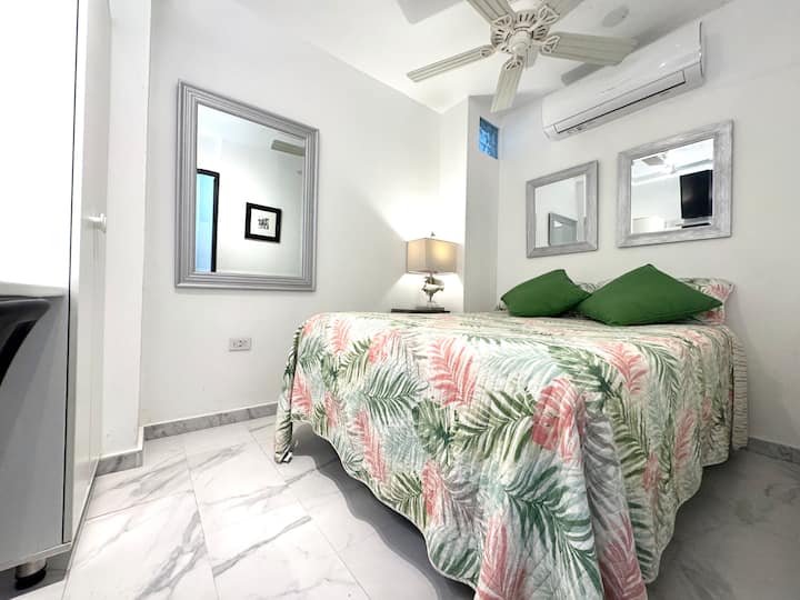 Kitanda cha ukubwa kamili kilicho na meza ya usiku na taa ya kusoma. 