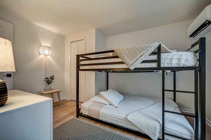 This bedroom has a bunkbed with two double beds. The modern, comfy feel appeals to both kids and adults. 