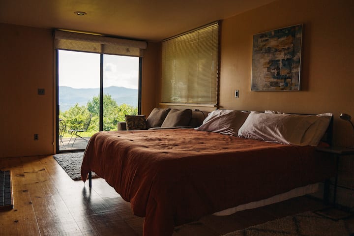 ห้องนอน 1 มีเตียงคิงไซส์เตาผิงทำงานตู้เสื้อผ้าแบบวอล์คอินทีวีห้องน้ำในตัวพร้อมหัวฝักบัวแบบสายฝนในห้องอาบน้ำฝักบัวแบบกระจกและอ่างแช่ตัว