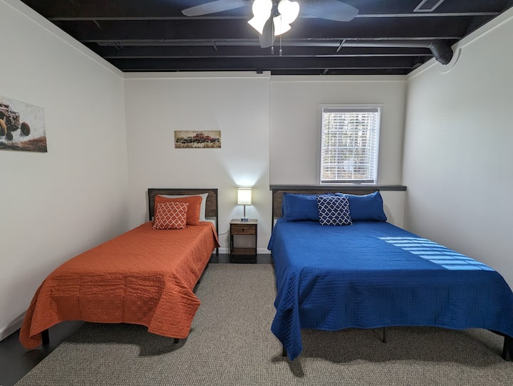 Slaapkamer vier bevindt zich in de kelder. Er is een queensize bed en een eenpersoonsbed, een nachtkastje, een elektrische open haard en een kast. 