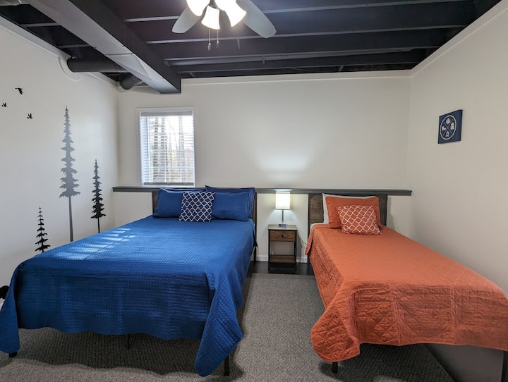 Slaapkamer vijf bevindt zich in de kelder. Er is een queensize bed en een eenpersoonsbed, een nachtkastje, een elektrische open haard en een kast. 