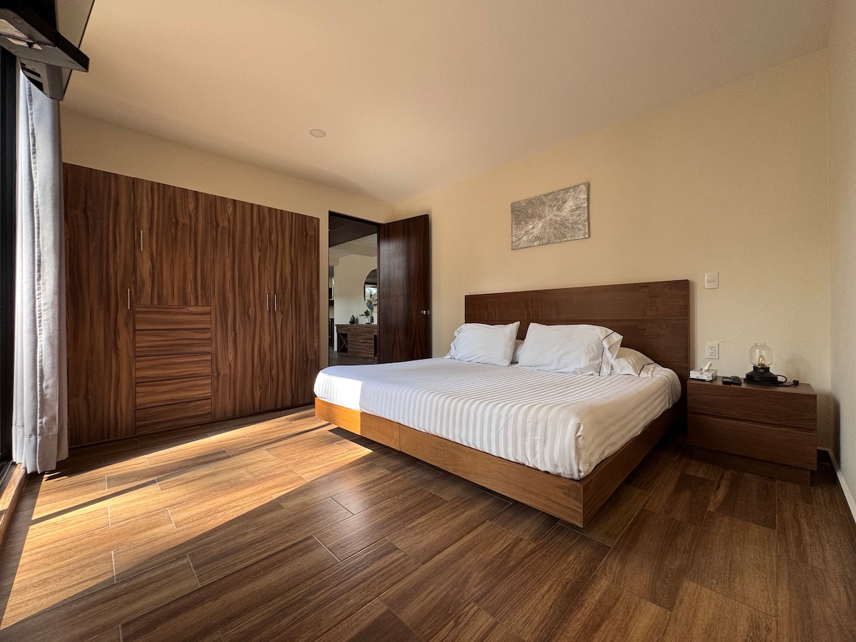 Camera al piano inferiore con un comodo letto matrimoniale grande, armadio, bagno e TV.