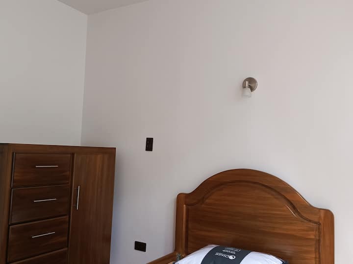 Táto izba ponúka pohodlnú a pol štvorcovú drevenú posteľ.