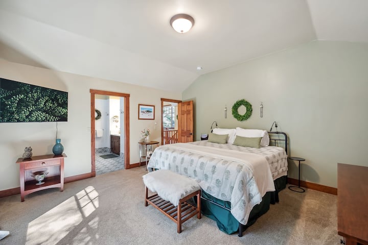 The primary bedroom has lots of space, a king size bed and ensuite bathroom