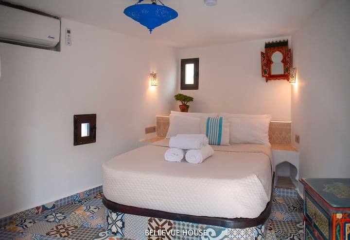 dormitorio con aire acondicionado, baño integrado y terraza
