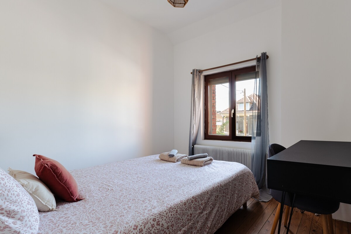 Habitación situada en la planta superior con cama Queen Size y escritorio, con vistas a un callejón tranquilo.