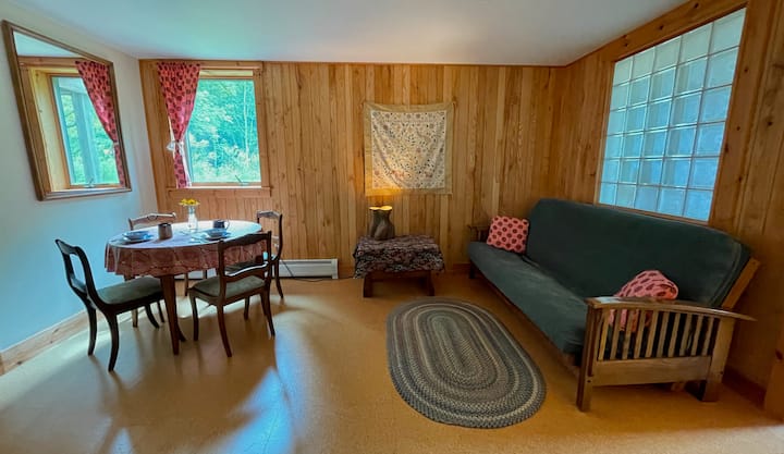Votre salon, avec table de petit déjeuner, un canapé convertible futon complet, etc.  Le sol en liège dans cette pièce et la chambre est très agréable sur les pieds ! Si vous avez besoin d'un hébergement de couchage dans cette chambre, nous aurons le futon fait pour vous.