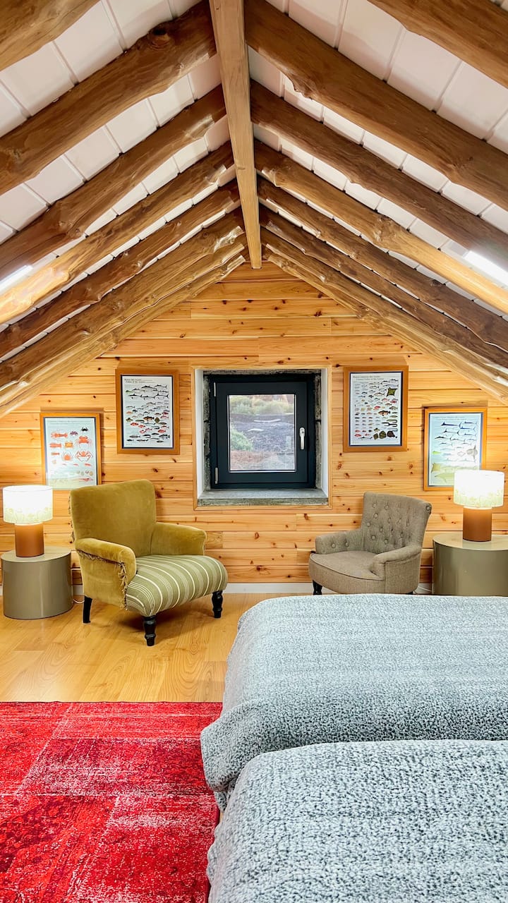 素朴な木製の梁と居心地の良いインテリアを備えた広々とした屋根裏部屋で、グループや家族での利用に最適です。 お部屋にはシングルベッド4台、柔らかい照明、カラフルなラグが備わっており、ゆったりとした夜を過ごすための温かく魅力的なリトリートを提供しています