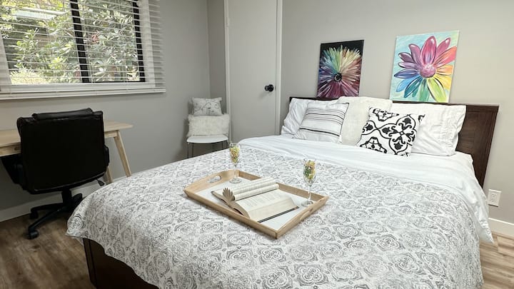 Spálňa s manželskou posteľou, písacím stolom, stoličkou a strešným oknom. 