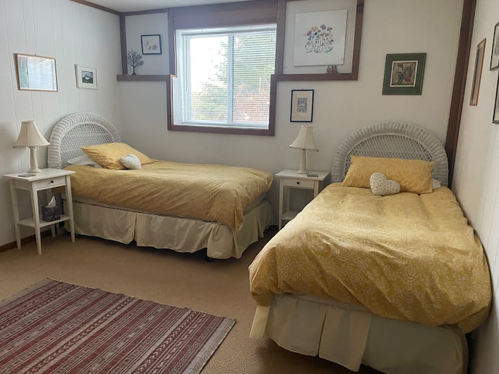 Chumba hiki cha kulala kina vitanda viwili, kabati, televisheni ya ziada na dirisha la kuingia kwenye bustani.