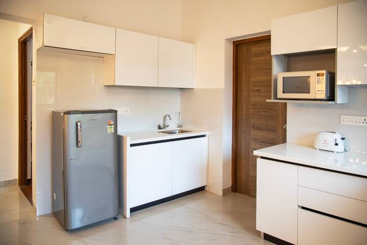 The kitchen is equipped with a stove, gas, kettle, fridge, and microwave, providing ample space for cooking.