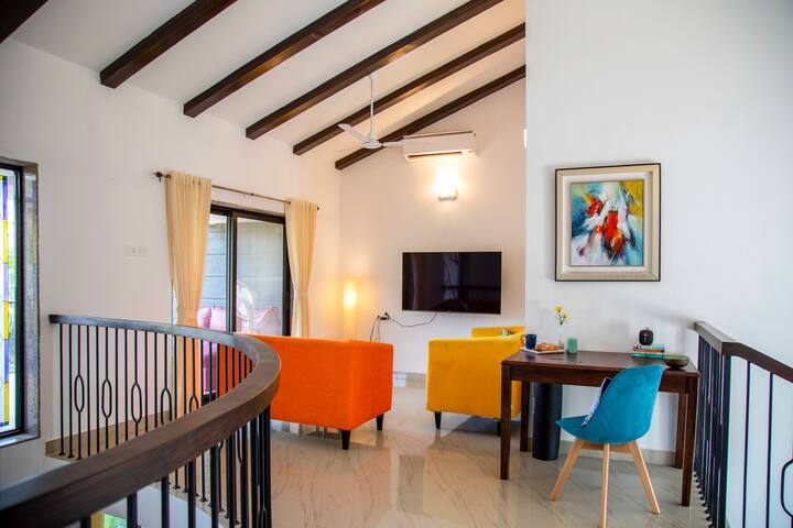 The first-floor TV room offers a relaxing atmosphere with access to a balcony and a swing.