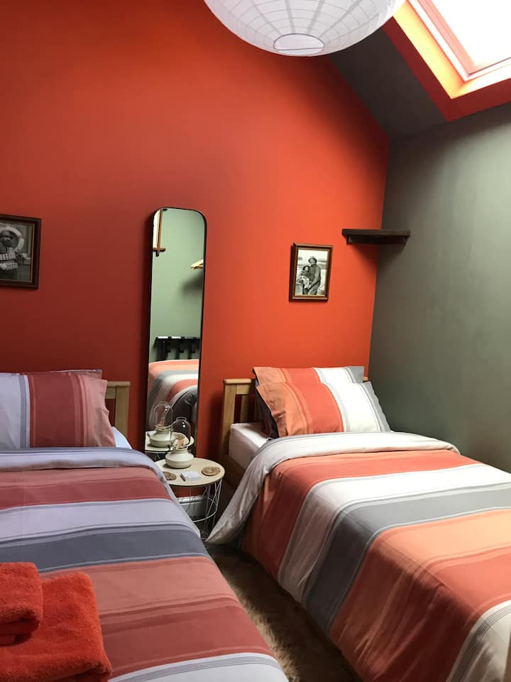 Dhomë gjumi e rehatshme dyshe me dritare të vetme velux. Është mirë të shikosh pulëbardhat në vazon e vjetër të oxhakut…dhe të shohësh se sa blu është qielli