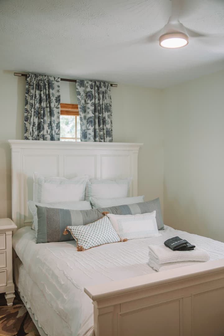 A bright and airy queen room on the first floor, designed for comfort and restful sleep.