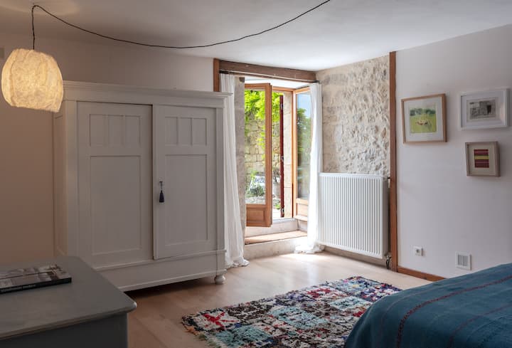 Dormitorio en planta baja con cama tamaño king y puertas francesas al jardín y a la piscina