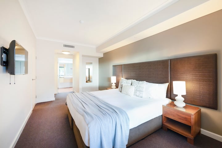 Брачната спална соба во станот вклучува целосна сопствена бања и телевизор за вечерна забава.