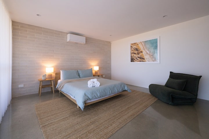 The front bedroom on the ground floor is a delight. It's spacious and inviting, with minimalist decor to create a peaceful ambient space for rest and sleep.