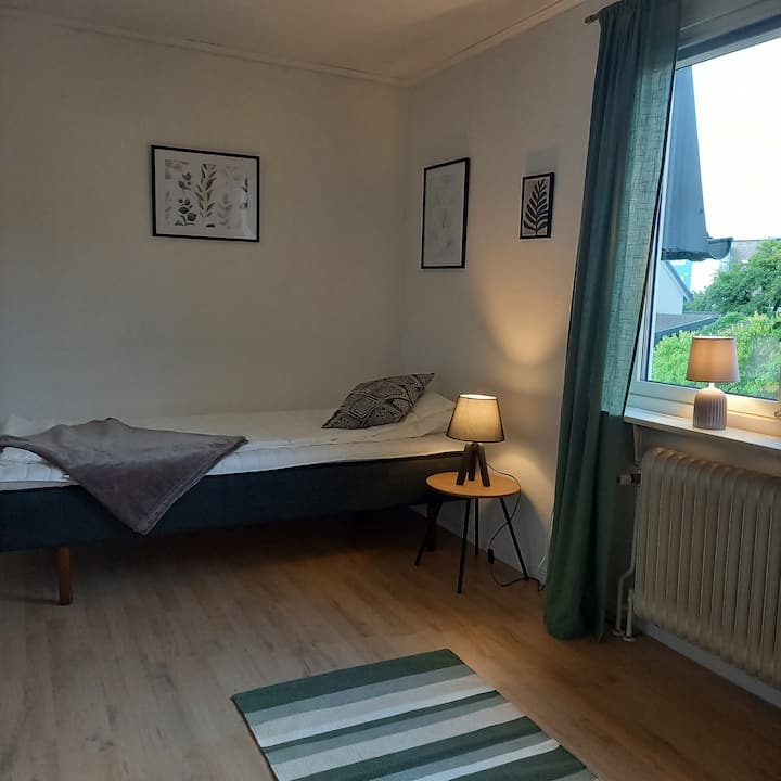 Chambre à l'étage avec un lit et une fenêtre donnant sur l'est.